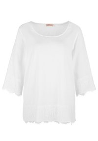 Haut léger blanc avec un décolleté arrondi et des manches en dentelle trois-quarts, présentant un tissu texturé et une bordure en dentelle festonnée à l'ourlet.