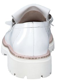 Witte gepatineerde leren schoenen met een stevige witte zool, een ronde achterkant en contrasterende beige stiksels langs de rand.