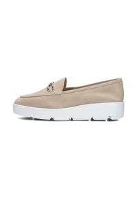 Beige suède instapper met een ronde neus, voorzien van een klein zilveren hardwareaccent en een stevige witte rubberen zool met zichtbare profiel.