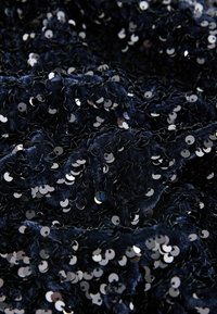 Navy sequined fabric with a soft texture, featuring closely spaced, circular sequins reflecting light, creating a shimmering effect.