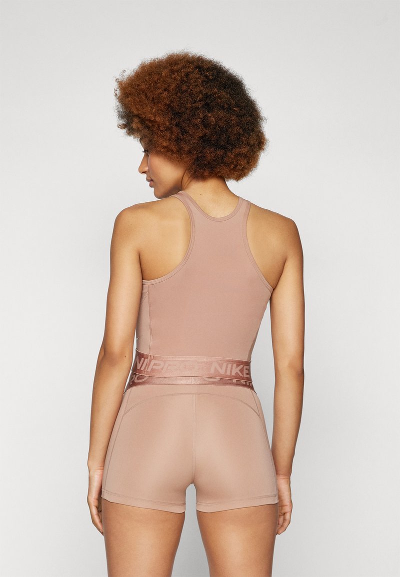 Set di canotta e pantaloncini sportivi in una tonalità beige attenuata. Realizzato in un tessuto liscio e elasticizzato. Presenta una vita elasticizzata ampia con branding.