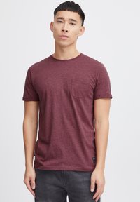 Bordeauxfarbendes Kurzarm-T-Shirt aus weichem Stoff, mit Rundhalsausschnitt und einer Brusttasche, feiner Textur und geradem Saum.