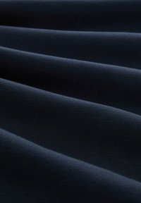 Tela de color azul oscuro con una textura suave, que presenta ligeras ondas y un patrón de superficie uniforme. Adecuada para diversas aplicaciones textiles.