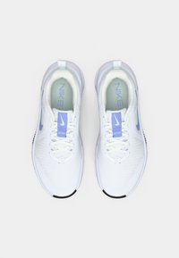 Hvite sportsko med lyseblå aksenter, mesh-overdel, rund tå, flat snøring og gummisul. Nike-logo på tungen og siden.