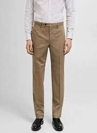 Pantaloni tailored bej cu o textură netedă, având un design cu față plată, buzunare laterale și închidere cu nasture. Purtați cu pantofi negri de dress.