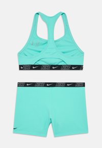 Gaismas zila sporta krūšturis un atbilstošas šortus ar melno Nike logu. Izgatavots no elastīga auduma, ar sacensību muguru.