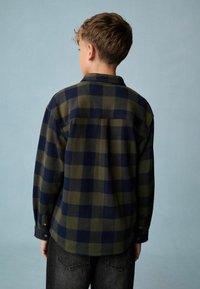 Flanellen shirt met een groen en marineblauw ruitpatroon, lange mouwen, knopenmanchetten en een klassieke kraag, van achteraf weergegeven.