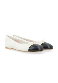 Ballerines avec une tige en textile blanc et un bout en cuir noir. Présentent un nœud décoratif central et une semelle en bois plate.
