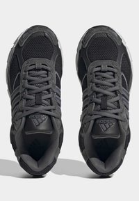 Melno un pelēko Adidas sporta apavu pāris ar sietiņu un zamšādu detaļām, skatoties no augšas uz baltas fona.