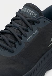 Σκούρο μπλε αθλητικό παπούτσι με επάνω μέρος από διχτυωτό υλικό, υφή με υφή και ενισχυμένη μύτη. Διαθέτει branding 'Air Cooled' και ανθεκτικά κορδόνια.