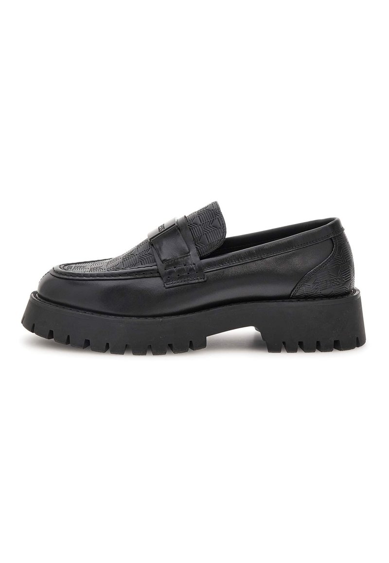 Zwarte leren loafer met een gepatenteerd bovenwerk, stevige lugsleutel en een banddetail over de bovenkant, weergegeven in zijaanzicht op een witte achtergrond.