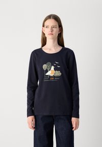 Tume sinine pika varrukaga T-särk, millel on linnu graafika ja puud. Valmistatud pehmest kangast, ümara kaeluse ja mugava lõikega.