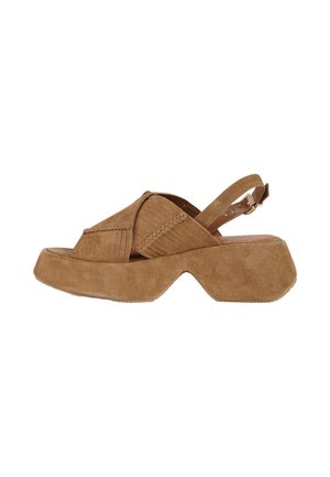 Sandalo platform in suede marrone con suola spessa scolpita, cinturini incrociati, dettaglio intrecciato e fibbia regolabile sul tallone.