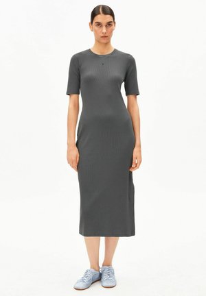 Graues, geripptes Midi-Kleid mit kurzen Ärmeln und Rundhalsausschnitt, mit kleinem Logo auf der Brust, kombiniert mit hellblauen Sneakern.