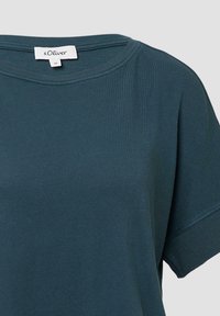 Donker teal T-shirt met korte mouwen en een ronde hals, gemaakt van gladde stof, met een label dat "s.Oliver" leest op de binnenkant van de hals.