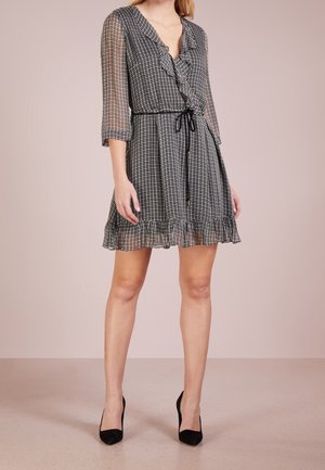 Czarna i biała sukienka w kratę z dekoltem w serek, falbanką, przezroczystymi rękawami do połowy przedramienia oraz ściągaczem w talii, z warstwowym dołem.