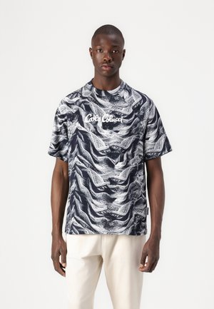 Short-sleeved, navy T-shirt with white abstract wave pattern. Features a round neckline and front logo text "Café Con Leche" in white.