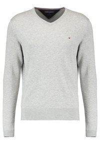 Suéter gris de cuello en V con mangas largas, textura de punto, puños y dobladillo acanalados, presenta un pequeño logo en el lado izquierdo del pecho.