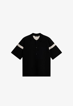 Czarna, krótko rękawek koszulka polo z teksturowanej tkaniny, z białym poziomym paskiem na rękawach. Zapięcie na guziki z przodu, klasyczny kołnierzyk.