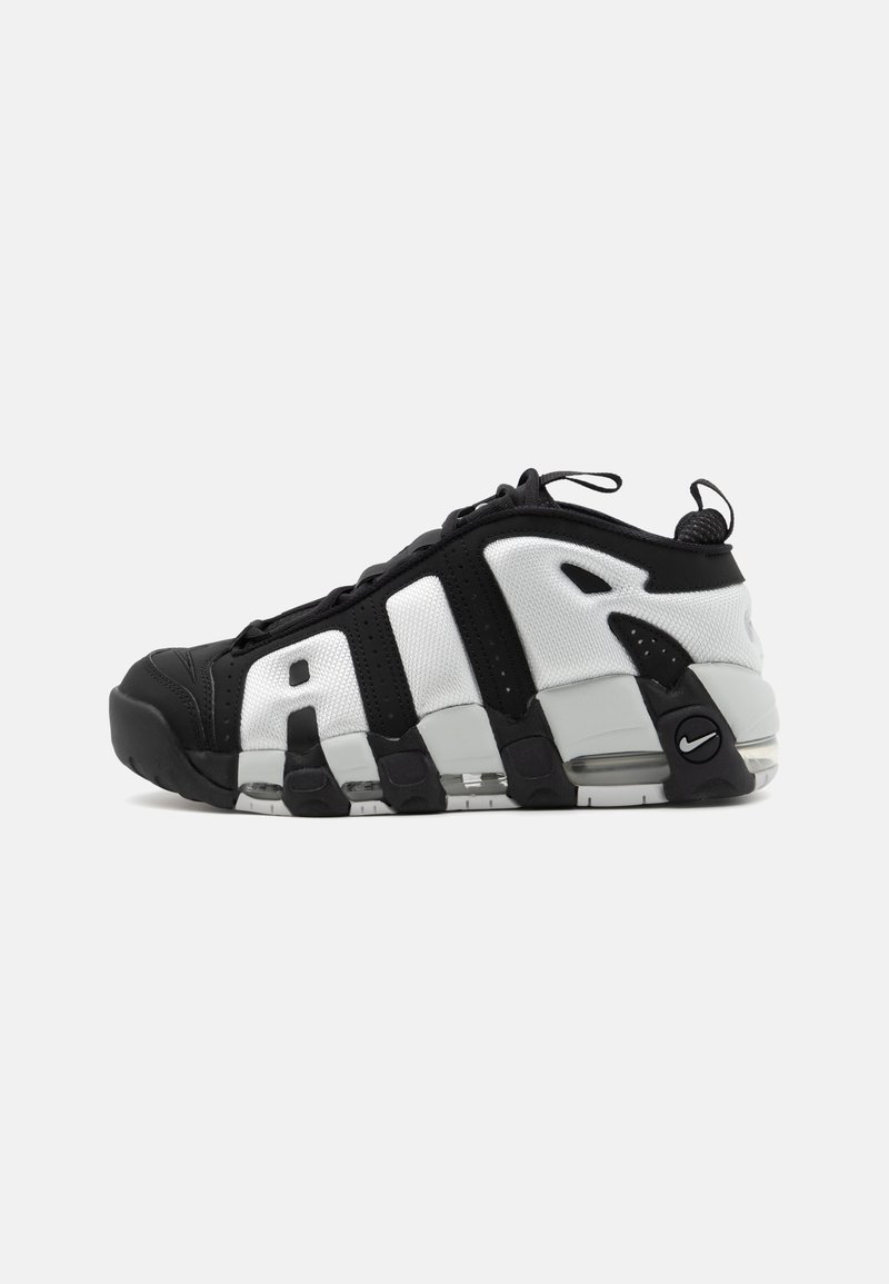 Mustvalge sportlik jalats, millel on tekstuuriga kangast ülemine osa, silmapaistvad triibud, pehme tallaga ja väike Nike logo kontsapooles.