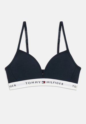 Marineblå trådløs BH med justerbare stropper og hvit elastisk bånd med Tommy Hilfiger-logo og flaggmerke.