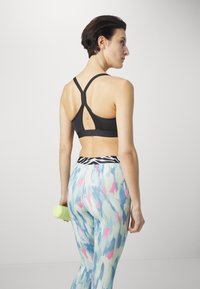 Puma KEEPS ULTRABARE STRAPPY - Vidutiniškai krūtinę prilaikanti sportinė liemenėlė - puma black