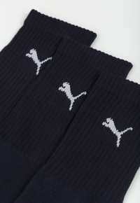 Ciemnoniebieskie skarpetki wykonane z materiału w prążki, z wyraźnym białym logo na każdej skarpetce. Klasyczny krój kostkowy.