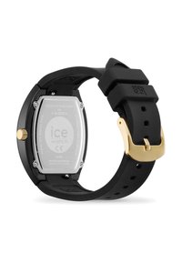 Schwarze Silikonarmbanduhr mit einem rechteckigen Edelstahlgehäuse, goldenen Beschlägen und gravierten Markendetails; wasserdicht bis 3ATM.