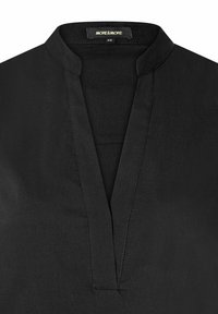 Black blouse featuring a mandarin collar and a v-neckline. Made from smooth fabric with subtle stitching details. Brand tag visible.