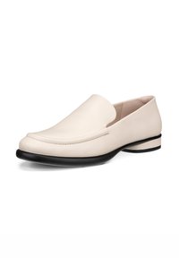 Béžové kožené mokasíny s hladkým povrchom, nízkou čiernou gumovou podrážkou a jemným prešívaním pozdĺž horného okraja. Klasický slip-on dizajn.