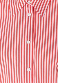 Rood-wit gestreept overhemd met een puntige kraag en eenvoudige witte knopen. Katoenen stof met een gladde textuur.