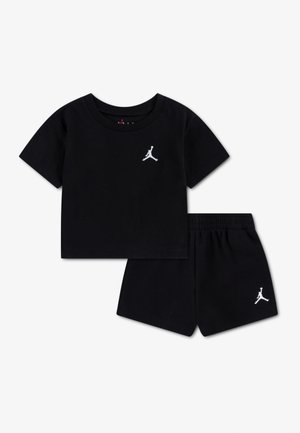 Schwarzes kurzärmeliges T-Shirt mit Rundhalsausschnitt und Shorts mit elastischem Bund, jeweils mit kleinem weißen Jumpman-Logo auf der linken Brust bzw. dem linken Bein.