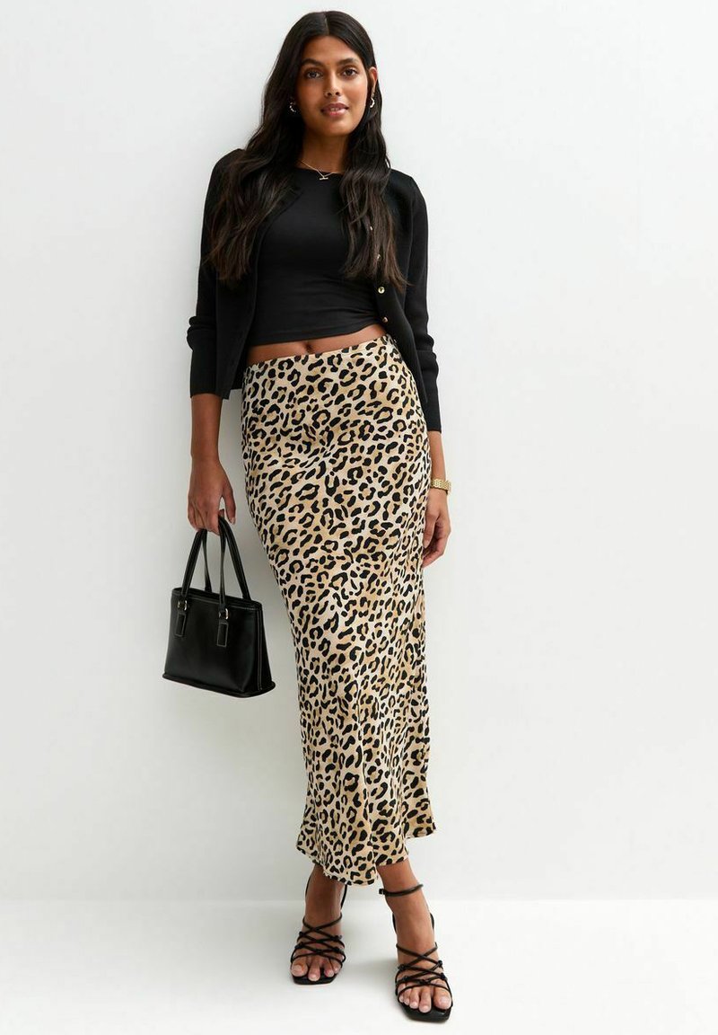 Black cardigan, fitted black top, leopard-print maxi skirt, strappy black sandals, and a small black handbag. Smooth fabric with a circular pattern.