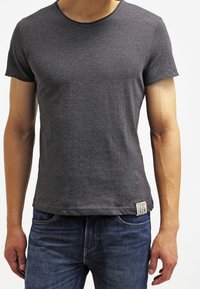 Grå kortærmet t-shirt lavet af bomuld, med rund hals og et lille mærke på siden med teksten "STEAM IRON."
