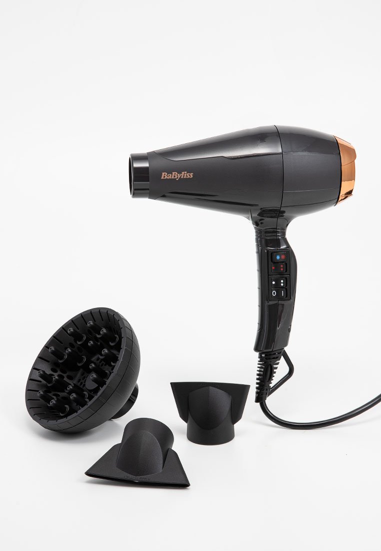 Czarna suszarka do włosów z miedzianymi akcentami, z zwężającą się dyszą i trzema końcówkami: dyfuzorem i dwoma koncentratorami. Sterowanie na uchwycie.