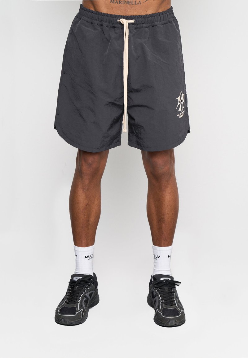 Svarta shorts med elastisk midja och beige dragsko, med en logotyp på vänster ben. Materialet verkar vara lätt och texturerat.
