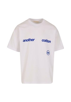 White cotton t-shirt featuring bold blue text "another," "cotton," and a circular "lab" logo on the left side. Short sleeves and relaxed fit.