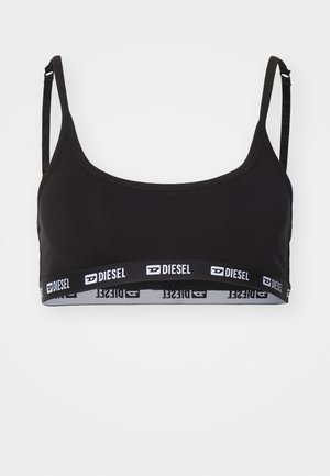 Bralette nera con spalline sottili e regolabili, scollatura rotonda e una fascia elastica con marchio bianco a contrasto nella parte inferiore. Texture liscia.