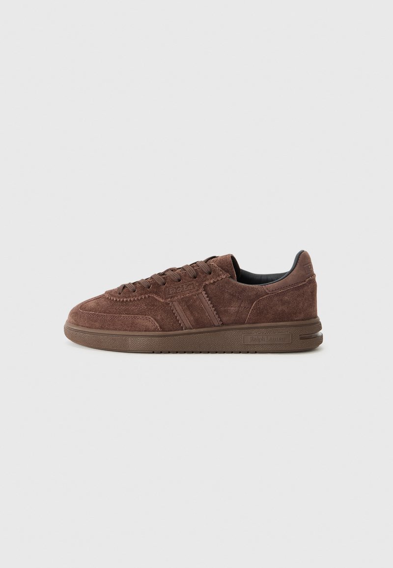 Brown suede sneaker with textured surface, flat lace-up design, and rubber outsole. Features logo and contrasting leather stripes.
