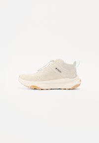 Lys beige treningssko med en teksturert syntetisk overdel, polstret såle og gummisåle for godt grep. Funksjoner inkluderer et snørelukking og logo.