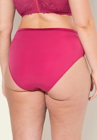 Hoch geschnittene rosa Unterhose aus glattem Stoff, mit sauberen Kanten und einem dehnbaren Bund. Minimalistisches Design ohne sichtbare Muster oder Akzente.