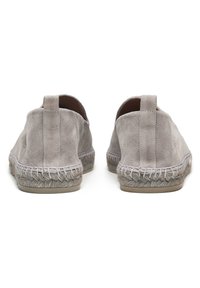 Zapatos de ante gris sin cordones con suela de yute trenzada y detalles cosidos, con puntera redondeada y parte trasera plana sin tacón.