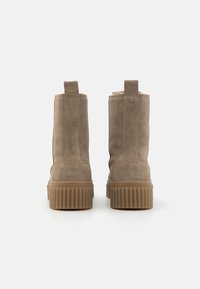 Καφέ σουέτ μποτάκια αστραγάλου με υφασμένη καουτσούκ σόλα, λαβές έλξης και μαλακή επένδυση, με λείο φινίρισμα και κομψό σχέδιο.