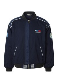 Veste bomber matelassée bleu marine avec col noir, passepoil blanc, fermeture éclair devant, poches latérales et écussons brodés sur la poitrine et les manches.