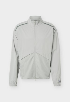Lichtgrijze jas met ritssluiting en hoge kraag, mesh aan de onderkant van de voorkant, elastische manchetten en reflecterende strepen op de schouders.