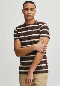 Brunrandig t-shirt i bomull med horisontella ränder i beige och blått. Kortingärmar och design med rundad hals.