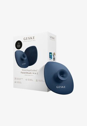 Brosse faciale en silicone bleu marine 4 en 1 Geske avec fixation ventouse, présentée aux côtés de son emballage blanc mettant en avant les caractéristiques clés et les récompenses.