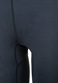 Schwarze Sportleggings aus glattem, dehnbarem Material, mit flachen Nähten und eng anliegendem Design. Keine sichtbaren Muster oder Akzente.