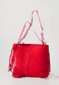 Borsa a mano in suede rosso dalla texture morbida, con un unico scomparto interno e una tracolla regolabile. Presenta un design minimalista e bordi non rifiniti.