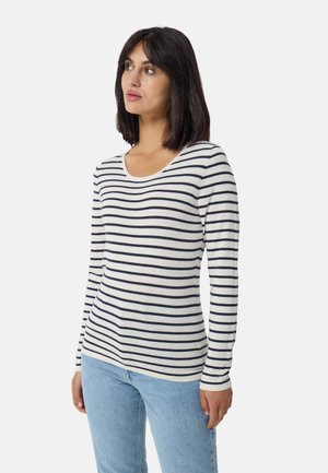 Langsleeve gestreepte blouse in crème en marineblauw, met een ronde hals en zachte, lichte stof. Gecombineerd met lichtblauwe jeans.